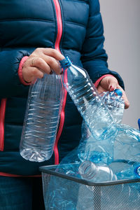 Midsection of woman holding water bottles