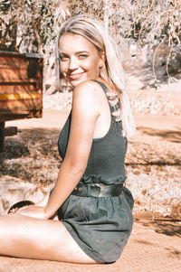 Portrait of a smiling young woman sitting outdoors