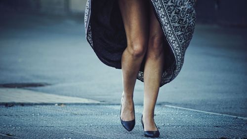 Low section of woman walking on street