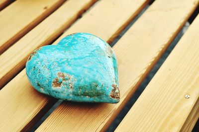 High angle view of blue heart shape rock on wooden table