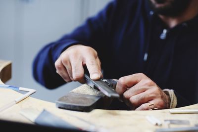 Midsection of man working at workshop