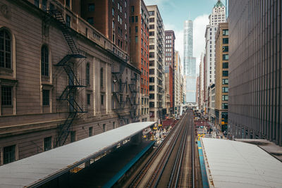 Railroad station amidst buildings in city against sky