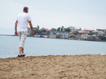 Full length rear view of a man walking on beach