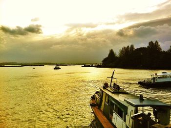 Boats in sea at sunset