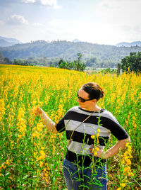 Rear view of young woman standing in field