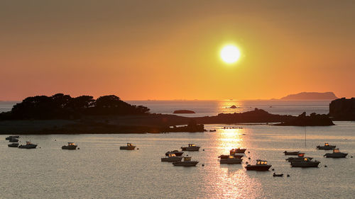 Silhouette boats on sea against sky during sunset