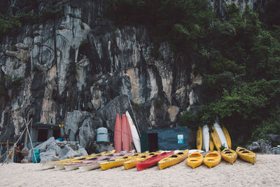 Boats moored at beach against rock formations