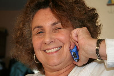 Close-up portrait of smiling woman talking on phone