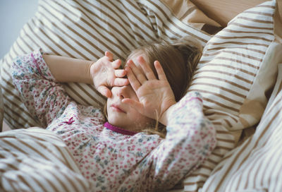 High angle view of cute girl sleeping on bed