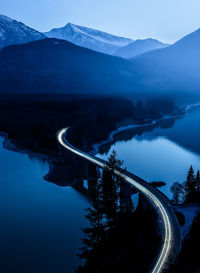 High angle view of light trails on bridge over river at dusk