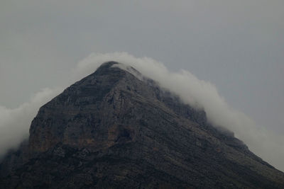 Low angle view of volcanic mountain against sky