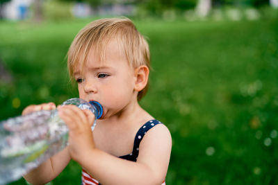 Close-up of cute baby drinking water outdoors