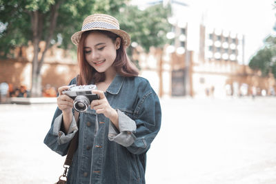 Young woman photographing on camera