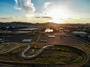 High angle view of winding road and parking lot against sky during sunset