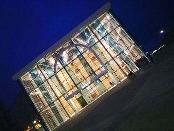Low angle view of illuminated building against sky at dusk