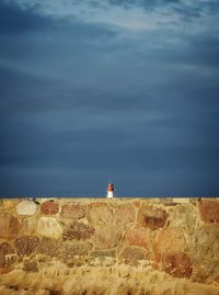 Lighthouse by sea against sky