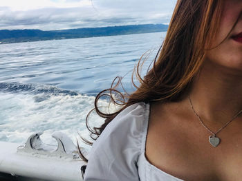 Woman on boat at sea against sky