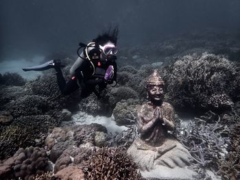 Scuba diving girl next to buddha