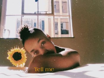 Portrait of woman lying down on window