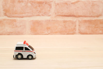 Close-up of toy car on table against wall