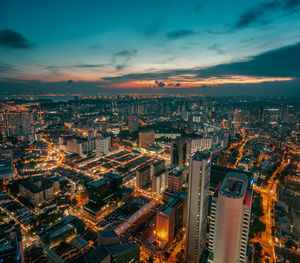 High angle view of city lit up against sky
