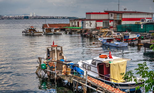 Fishing boats moored at harbor in city