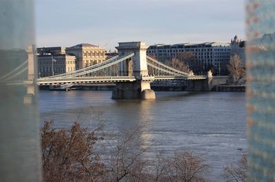 Bridge over river with city in background