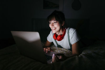 Portrait of boy using laptop while sitting on sofa at home