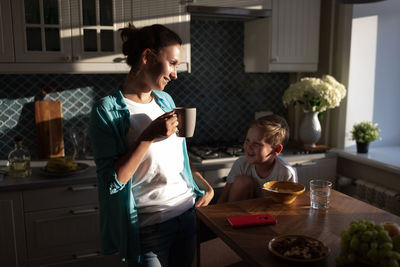 Happy woman and boy having breakfast together