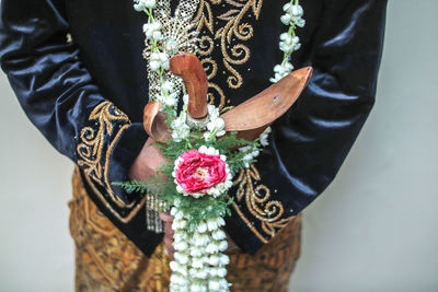 Midsection of woman holding flowering plant