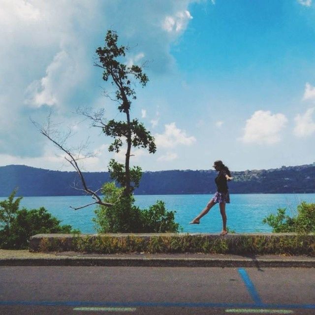 sky, water, full length, lifestyles, leisure activity, rear view, casual clothing, cloud - sky, men, standing, tree, cloud, lake, nature, tranquility, side view, beauty in nature, sea