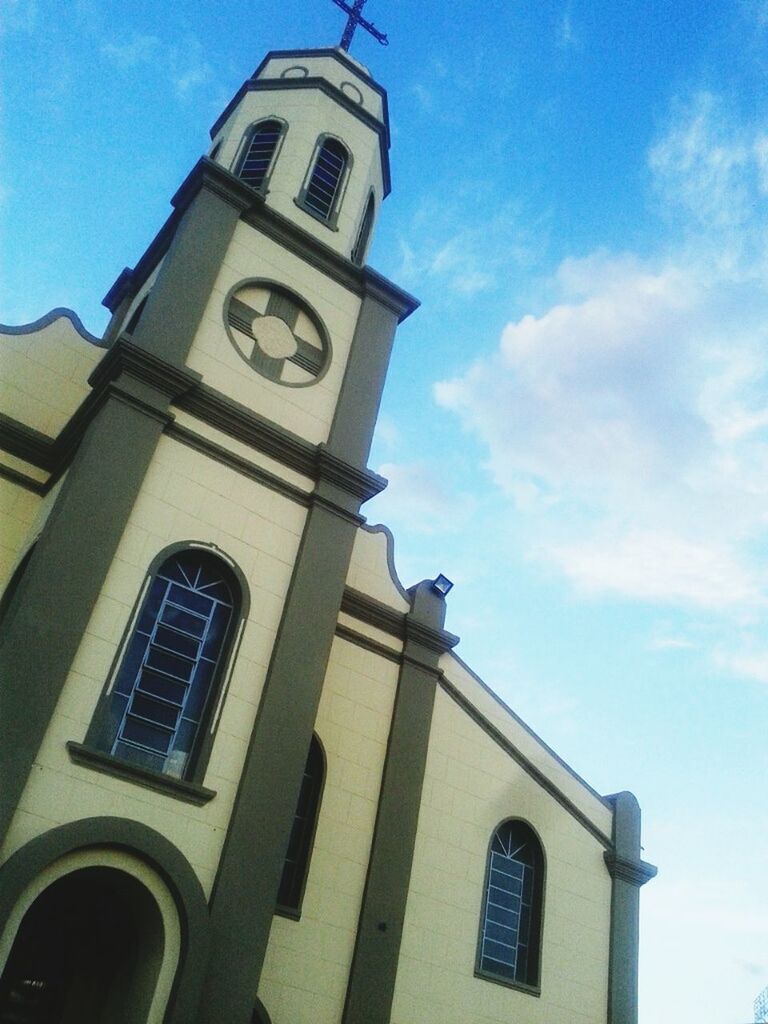 building exterior, architecture, low angle view, built structure, sky, church, religion, window, blue, place of worship, high section, clock tower, outdoors, sunlight, facade, day, cloud, no people, arch