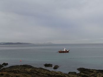 Boat sailing in sea against sky