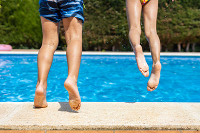 Low section of woman standing in swimming pool