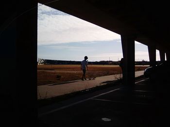 Man standing on road against sky