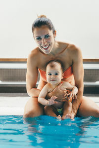 Portrait of smiling mother and son in swimming pool