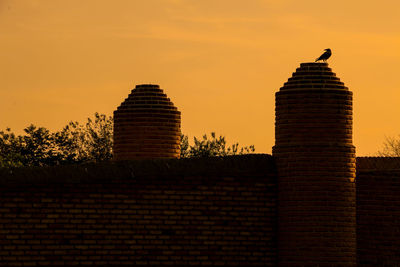 Low angle view of silhouette building against sky during sunset
