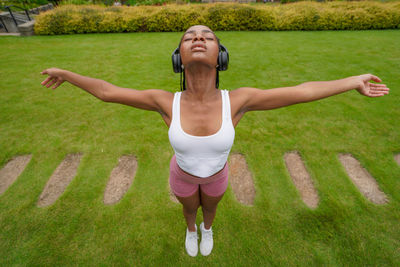 Portrait of young woman exercising on field