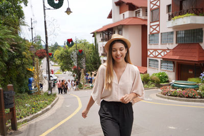 Portrait of young woman standing in city