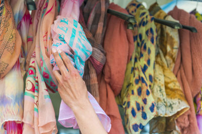 Cropped hand holding scarf hanging for sale at market