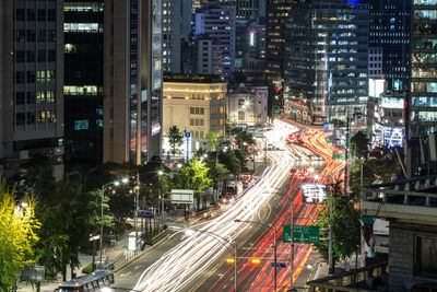Blurred motion of vehicles on road along buildings