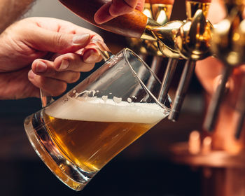 Cropped hand of man holding beer glass