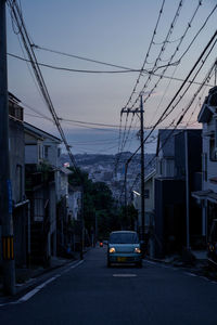 Cars on road amidst buildings in city at dusk