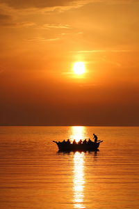 Silhouette boat in sea against sky during sunset