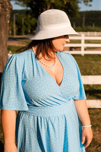 Midsection of woman wearing hat standing outdoors