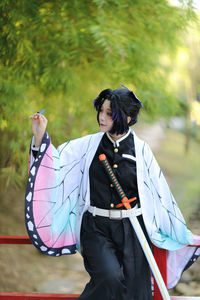 Young woman holding dragonfly outdoors