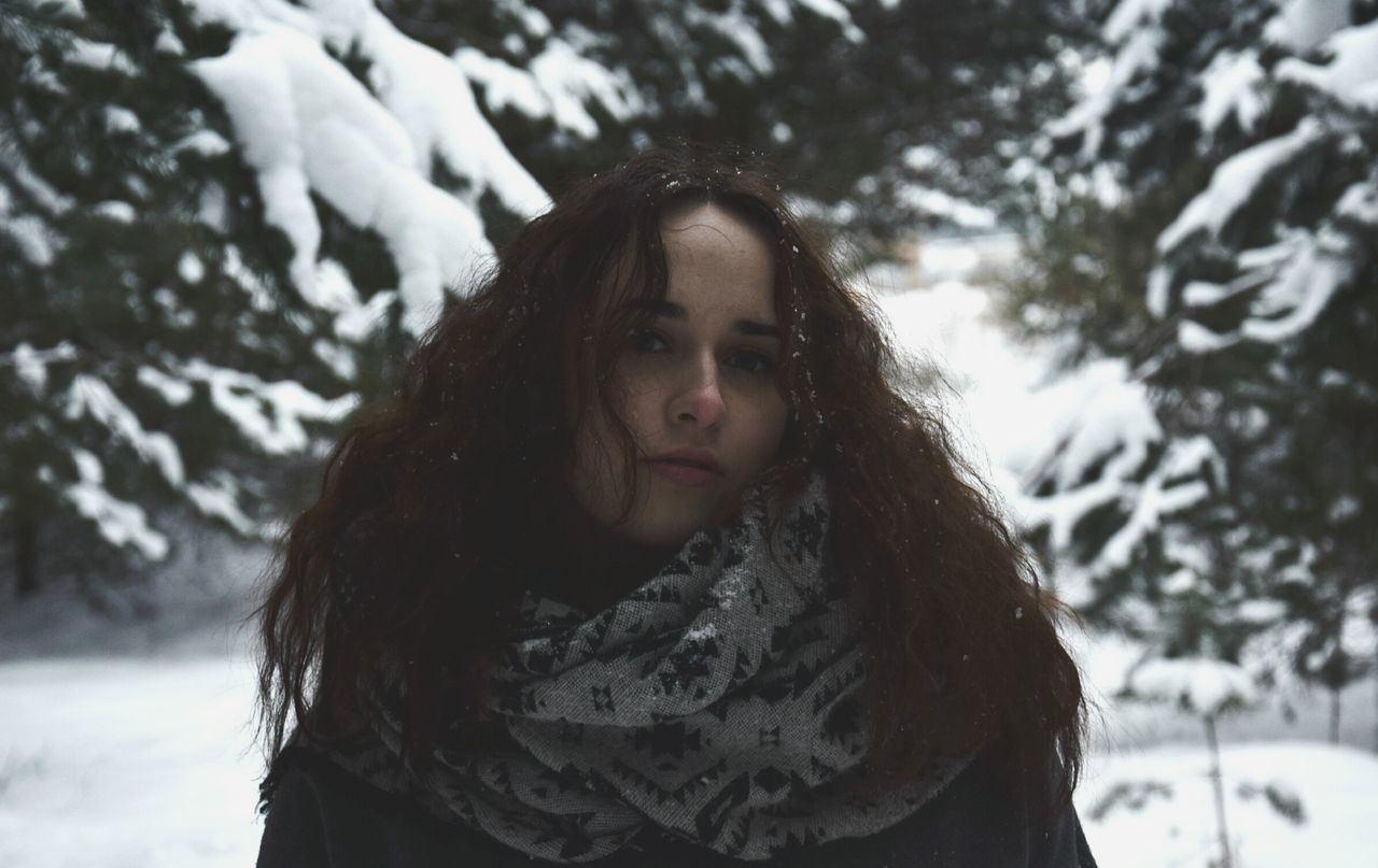 snow, winter, cold temperature, nature, weather, focus on foreground, real people, long hair, one person, tree, outdoors, day, front view, leisure activity, looking at camera, young women, lifestyles, young adult, standing, warm clothing, beautiful woman, beauty in nature, portrait, close-up