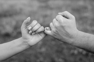 Close-up of people holding little finger