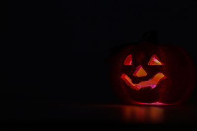 Close-up of illuminated pumpkin against black background