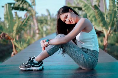 Side view of a young woman sitting outdoors